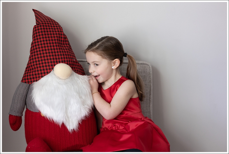 Little girl is whispering a secret to a giant gnome at her Ridgewood studio photo session