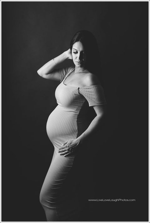 Photo of a pregnant woman posting at a maternity session in Ridgewood photo studio